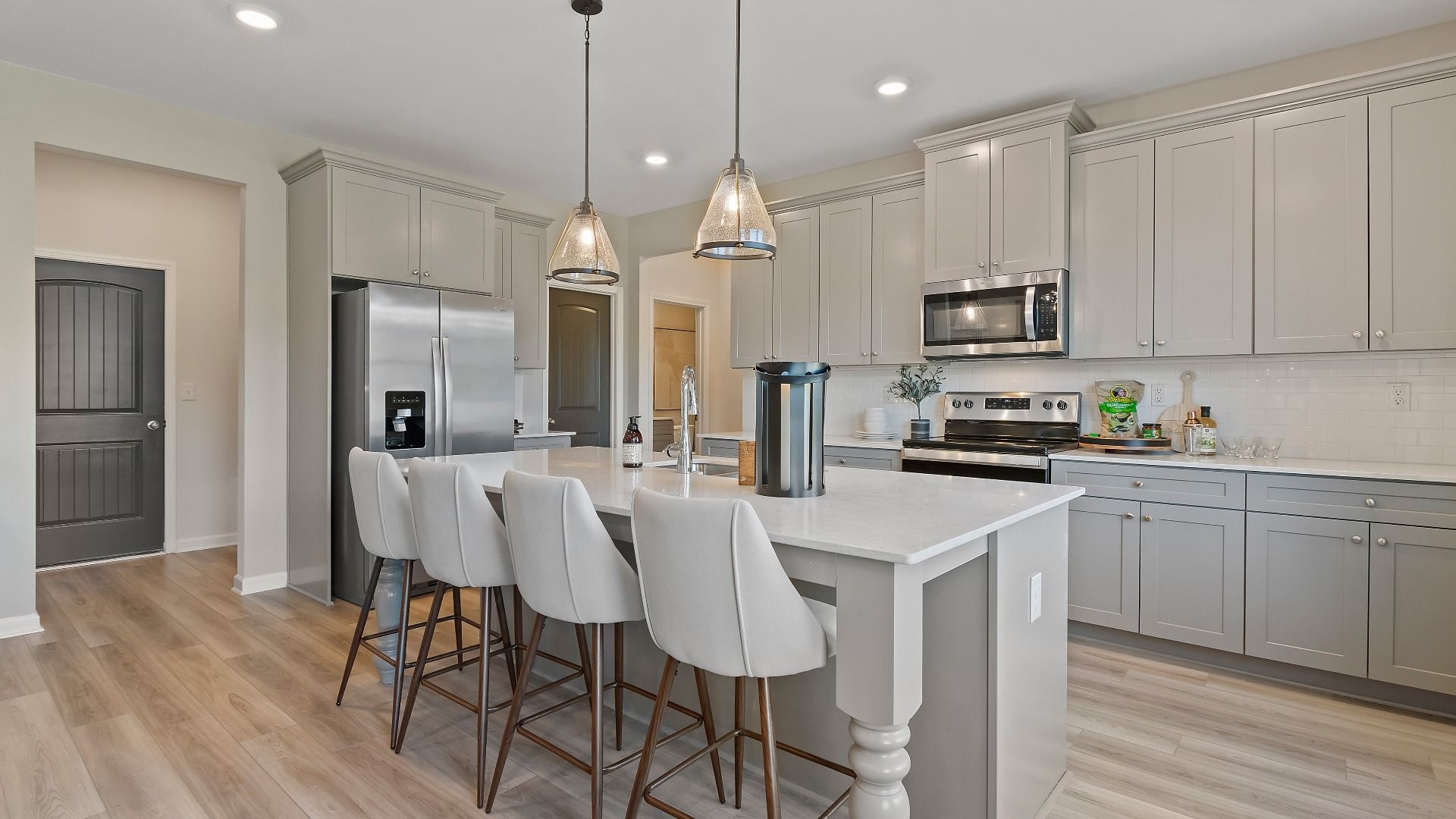 Modern gray kitchen with expansive island and stainless steel appliances in new construction home in Dacula, GA.