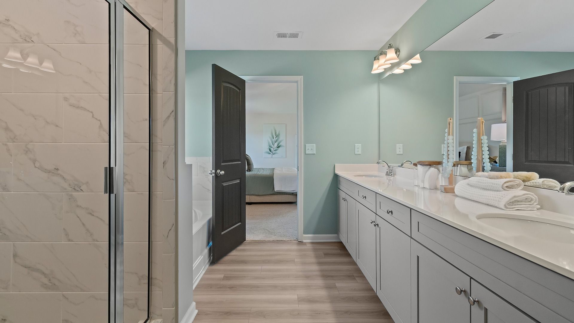 Luxury primary bathroom with double vanity and tile shower in new construction home at Adagio in Dacula, Georgia.
