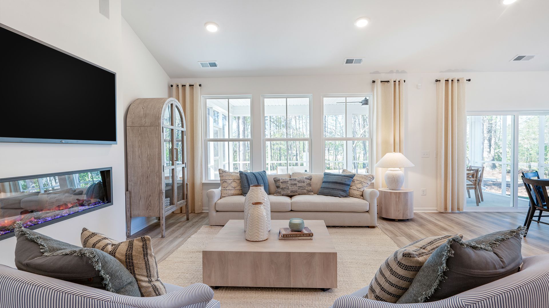 Living room Avondale model in Bluffs at Sun Colony by DRB homes offering electric fireplace and big open windows