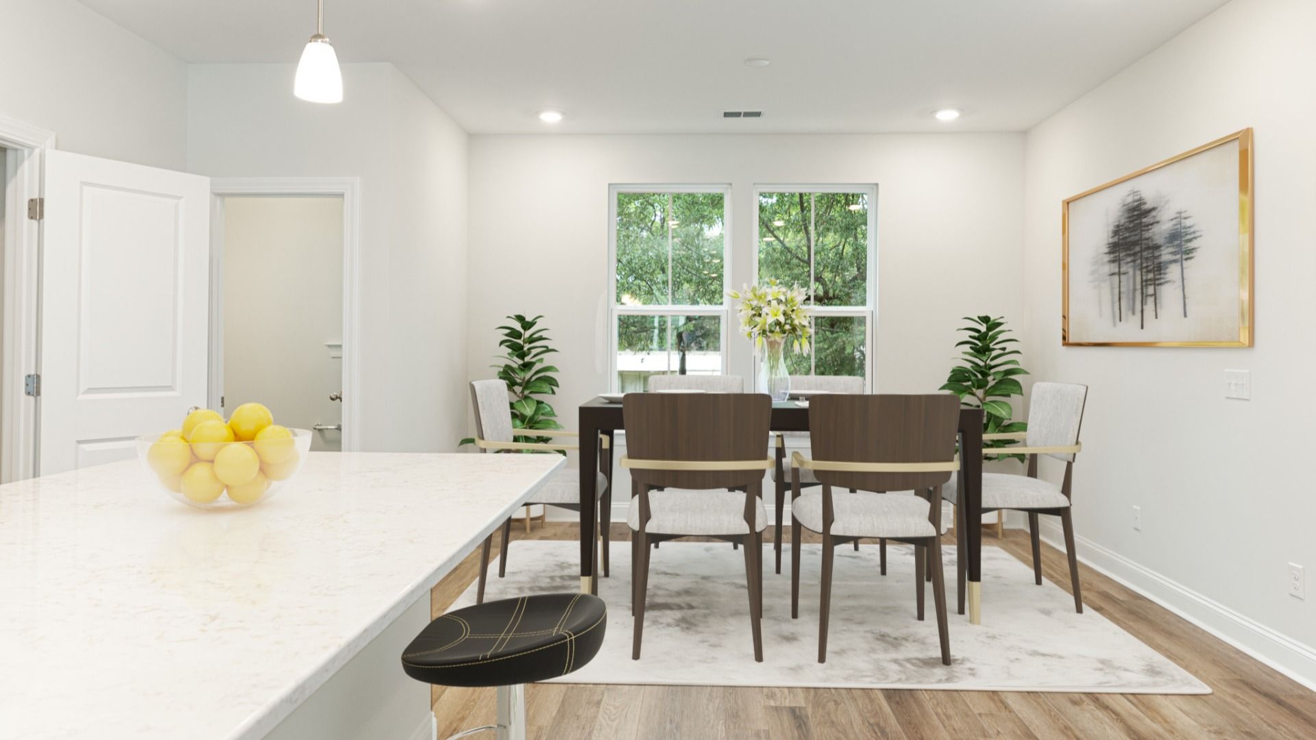 Island kitchen & dining area with 2 large windows in a DRB Homes Brookgreen model home at the Park Circle Station community.