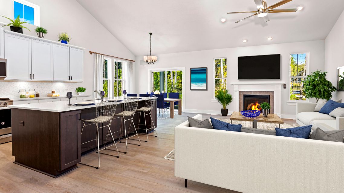 Kitchen and  family room with fireplace and vaulted ceiling in a DRB Homes Latitude home.