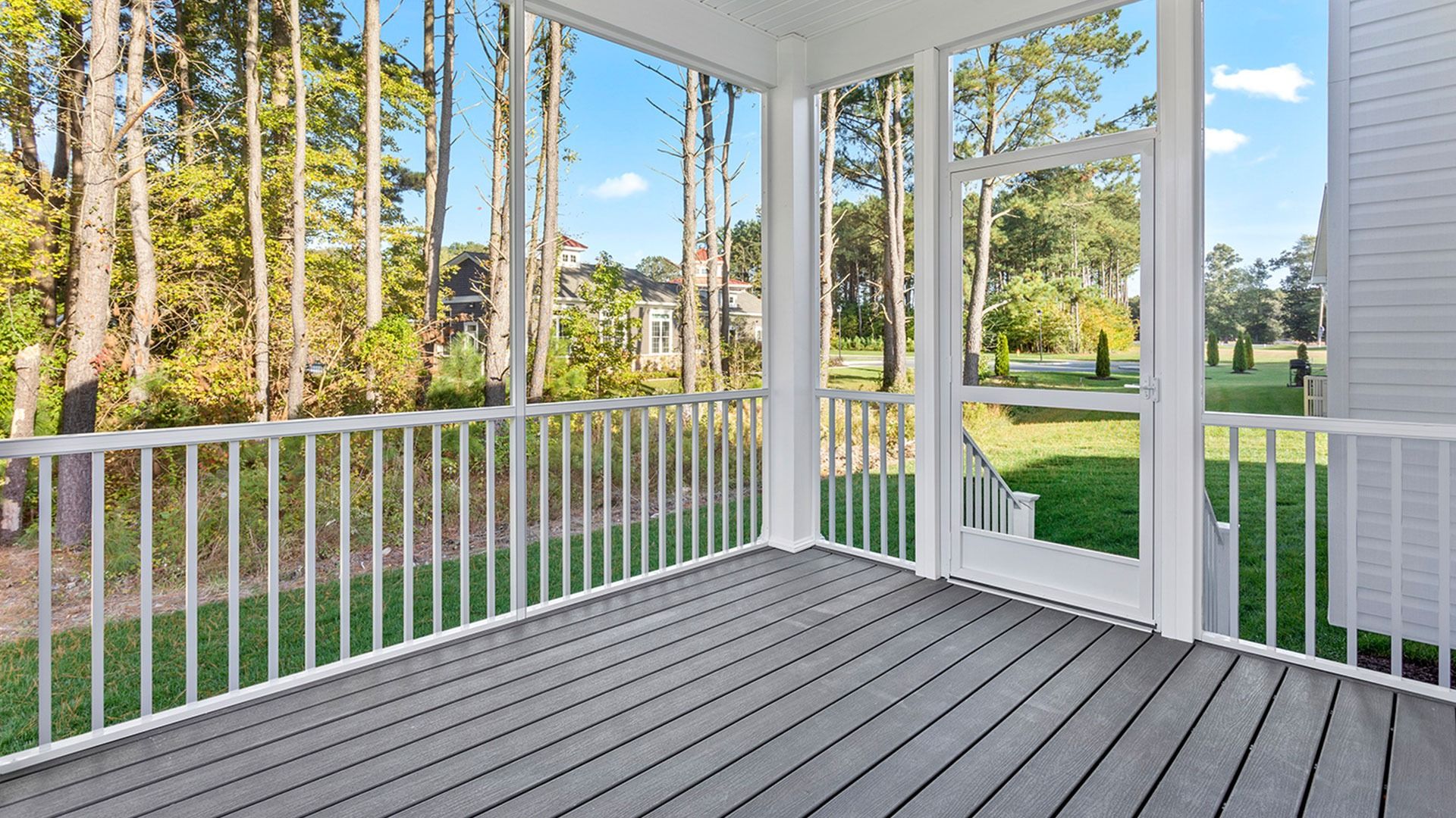 Rear screened porch with white railings and ceiling fan in a DRB Homes Latitude home.