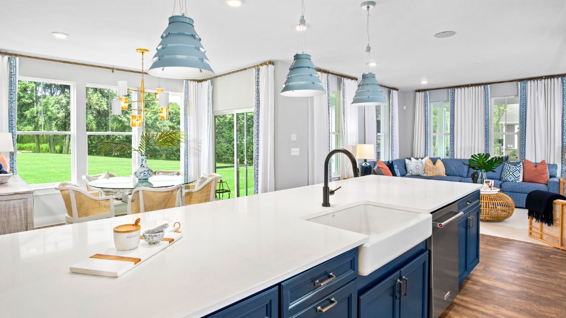 Open kitchen with large island, adjacent dining area morning room in a DRB Homes St. Kitts Model Home.