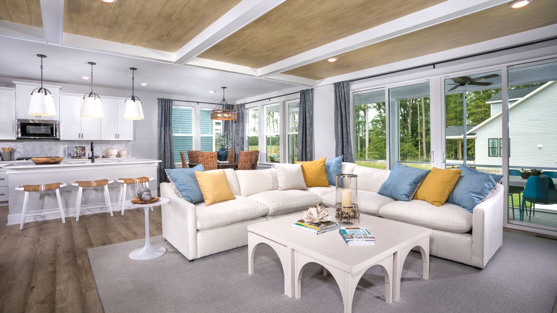 Open kitchen, dining area and family room with seating in a DRB Homes St. John Model Home.