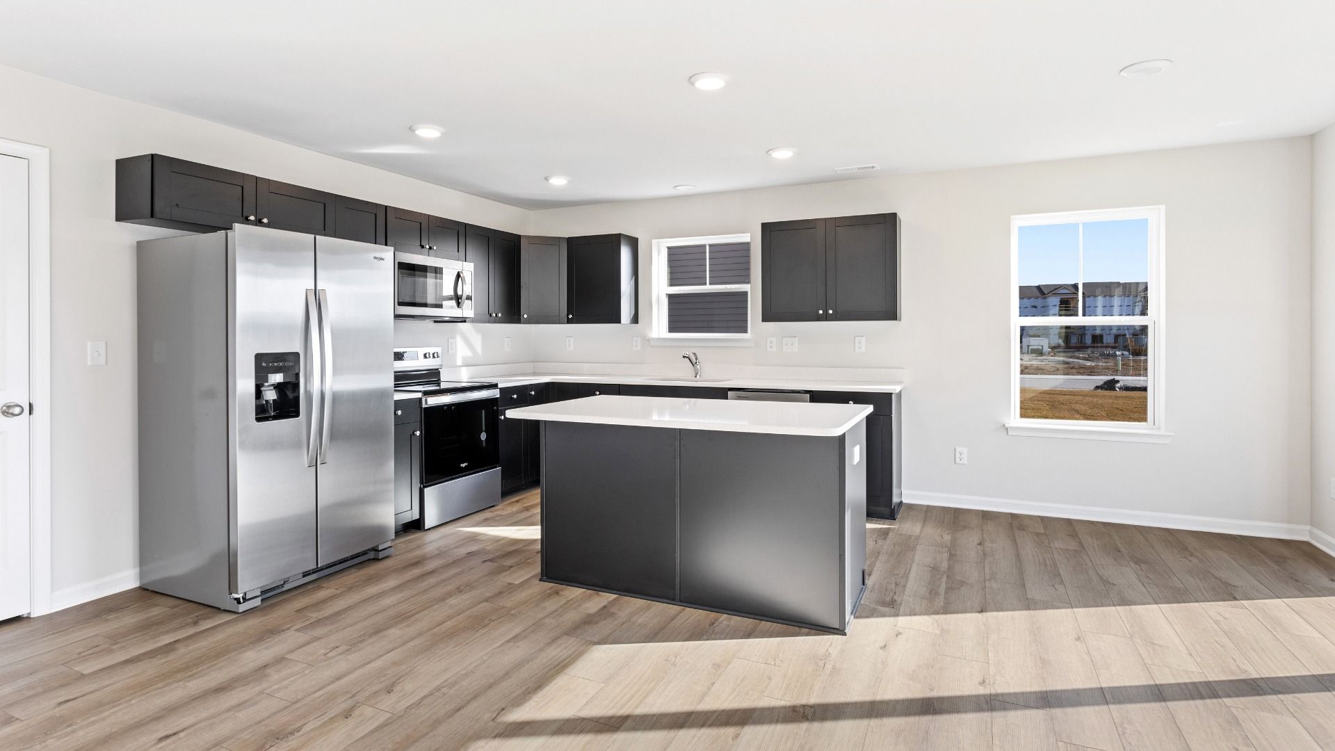 Island kitchen with dark gray cabinets in a DRB Homes Cranberry plan at the Village of College Park community.