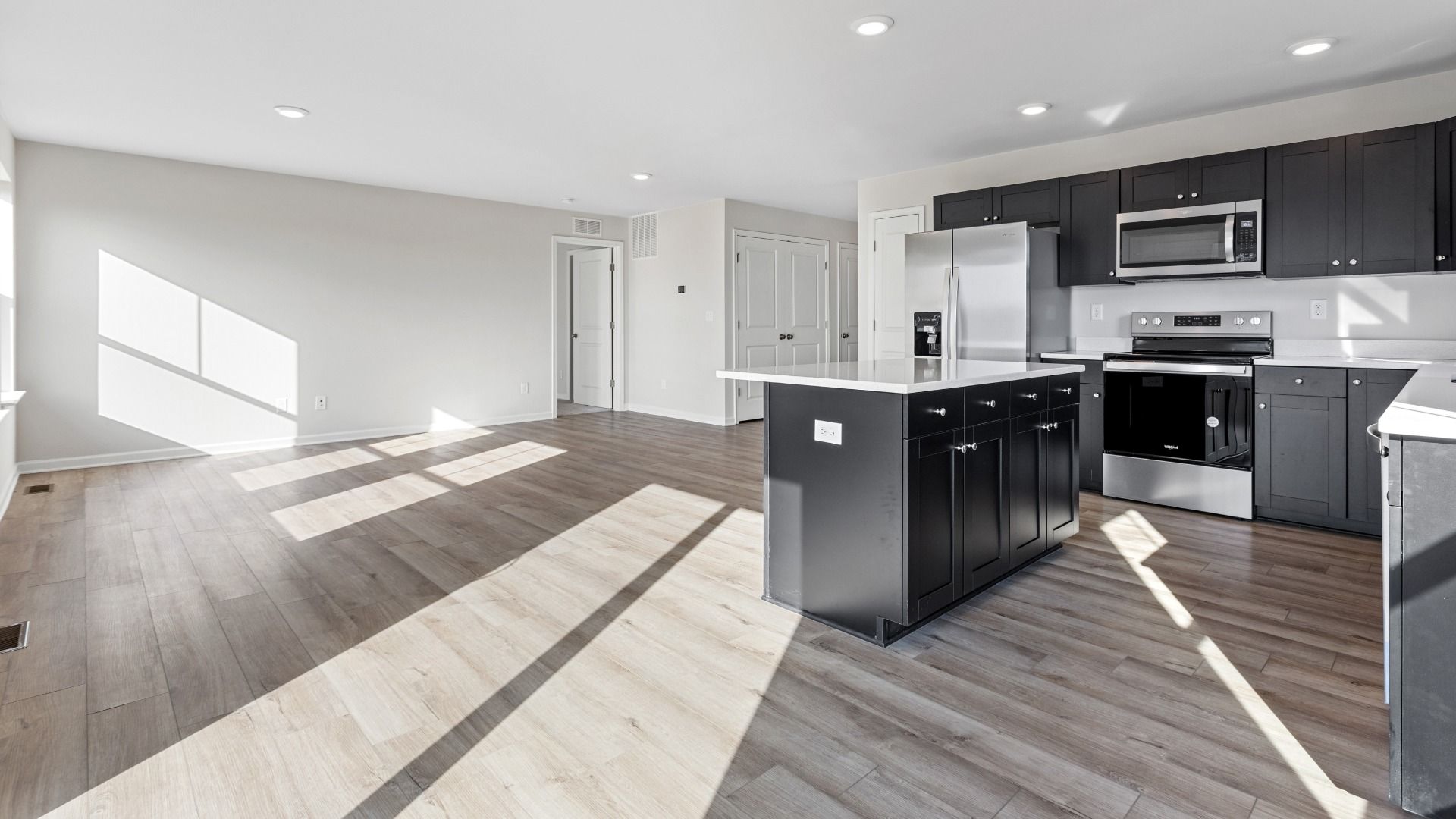 Open main floor kitchen and family room in a DRB Homes Cranberry plan at the Village of College Park community.