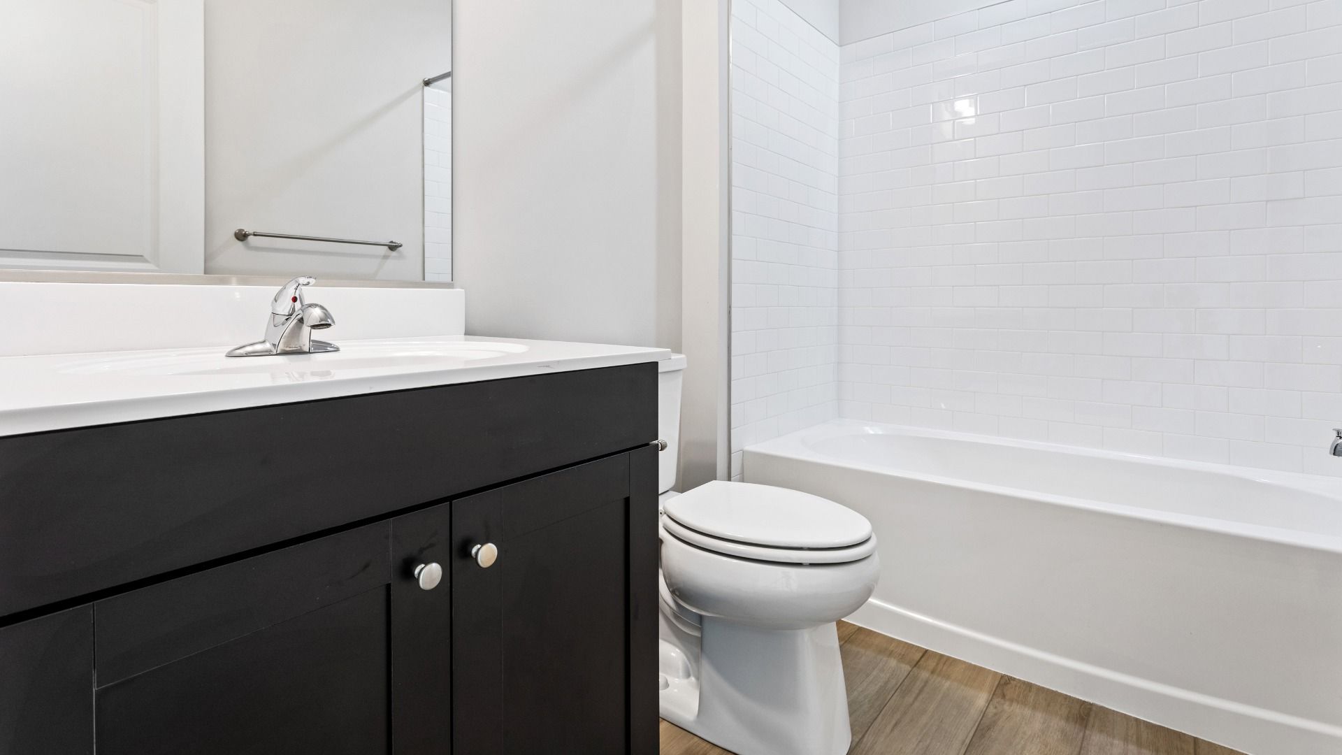 Full bath with dark vanity and shower/tub combo in a DRB Homes Cranberry plan at the Village of College Park community.