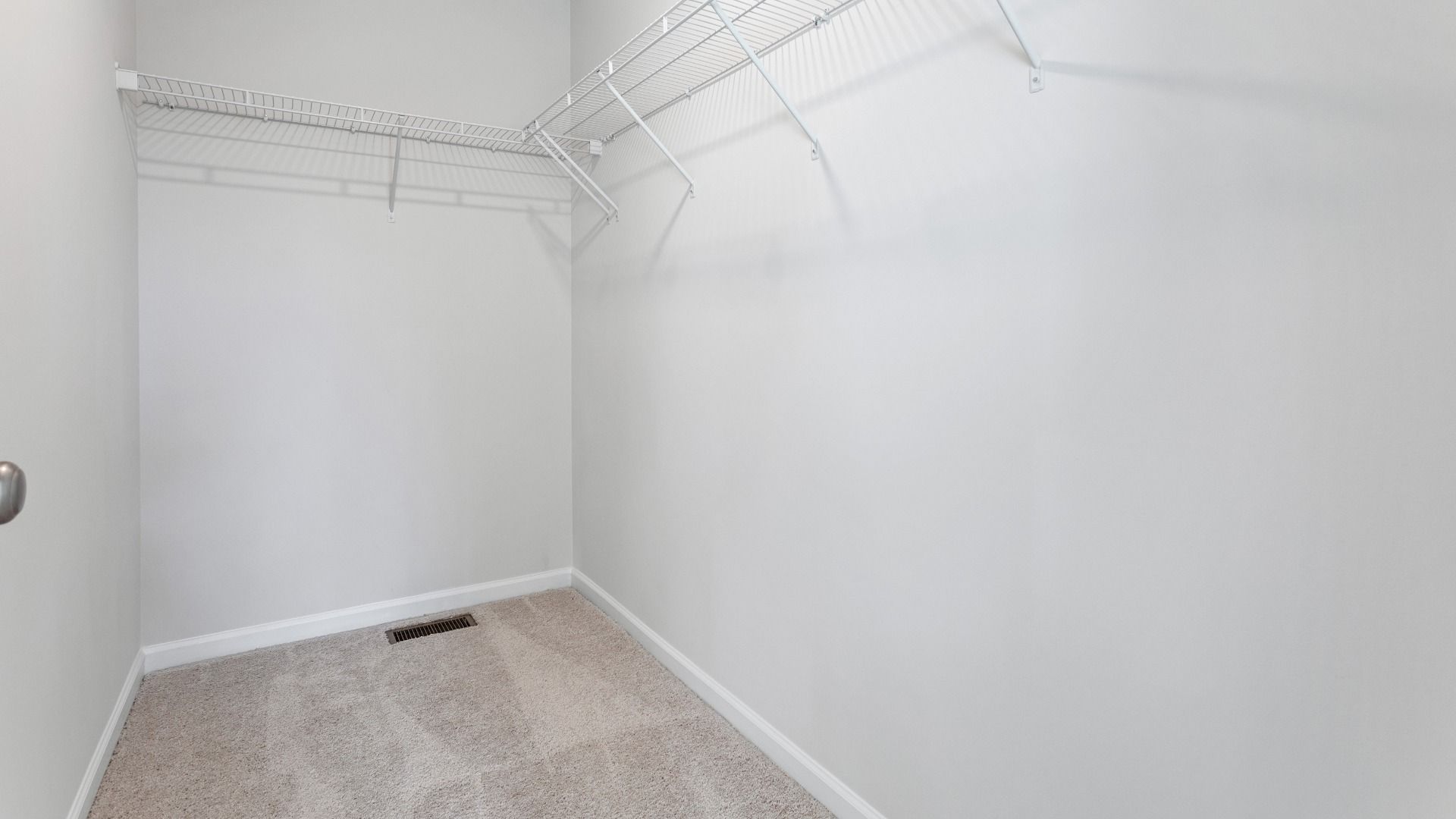 Carpeted walk-in closet in owner's suite in a DRB Homes Cranberry plan at the Village of College Park community.
