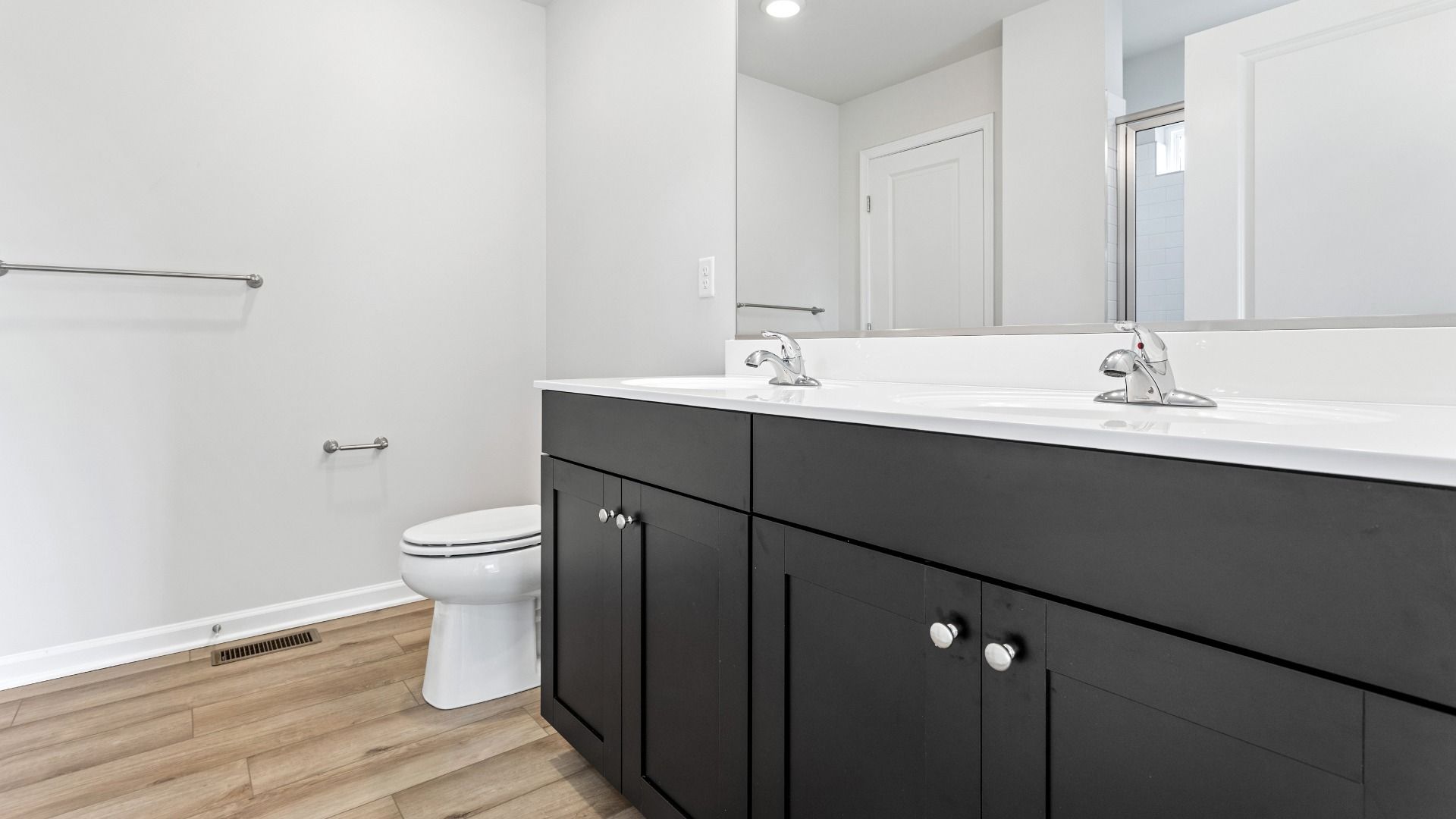 Owner's bath with dark, dual sink vanity in a DRB Homes Cranberry plan at the Village of College Park community.