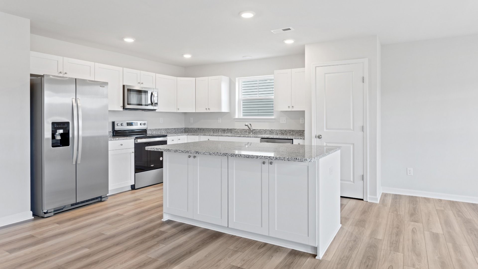 Island kitchen with white cabinets in a DRB Homes Edgewood plan at The Village of College Park community.