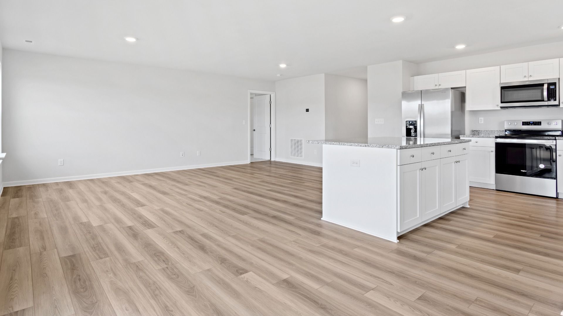 Island kitchen overlooking family room in a DRB Homes Edgewood plan at The Village of College Park community.