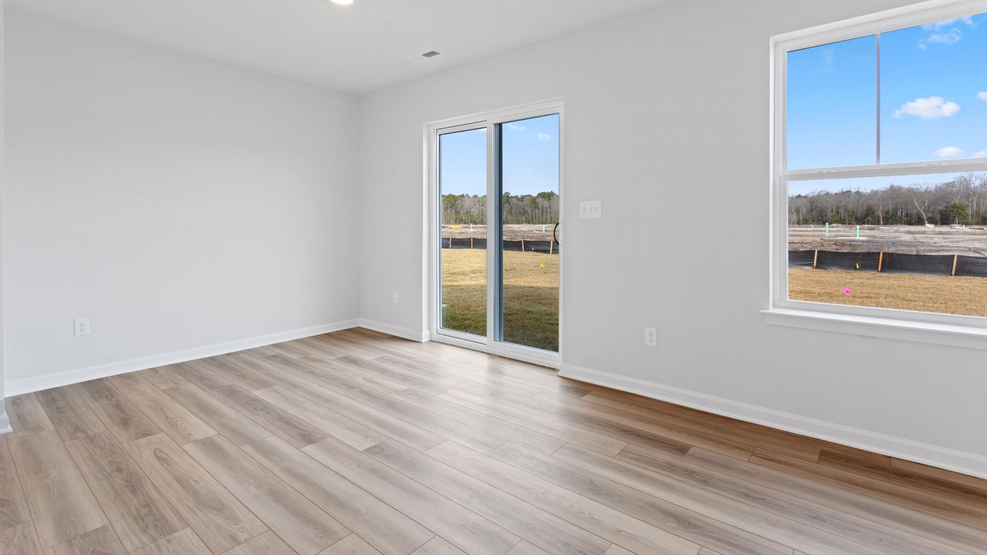 Dining area with sliding glass door to back yard in a DRB Homes Edgewood plan at The Village of College Park community.