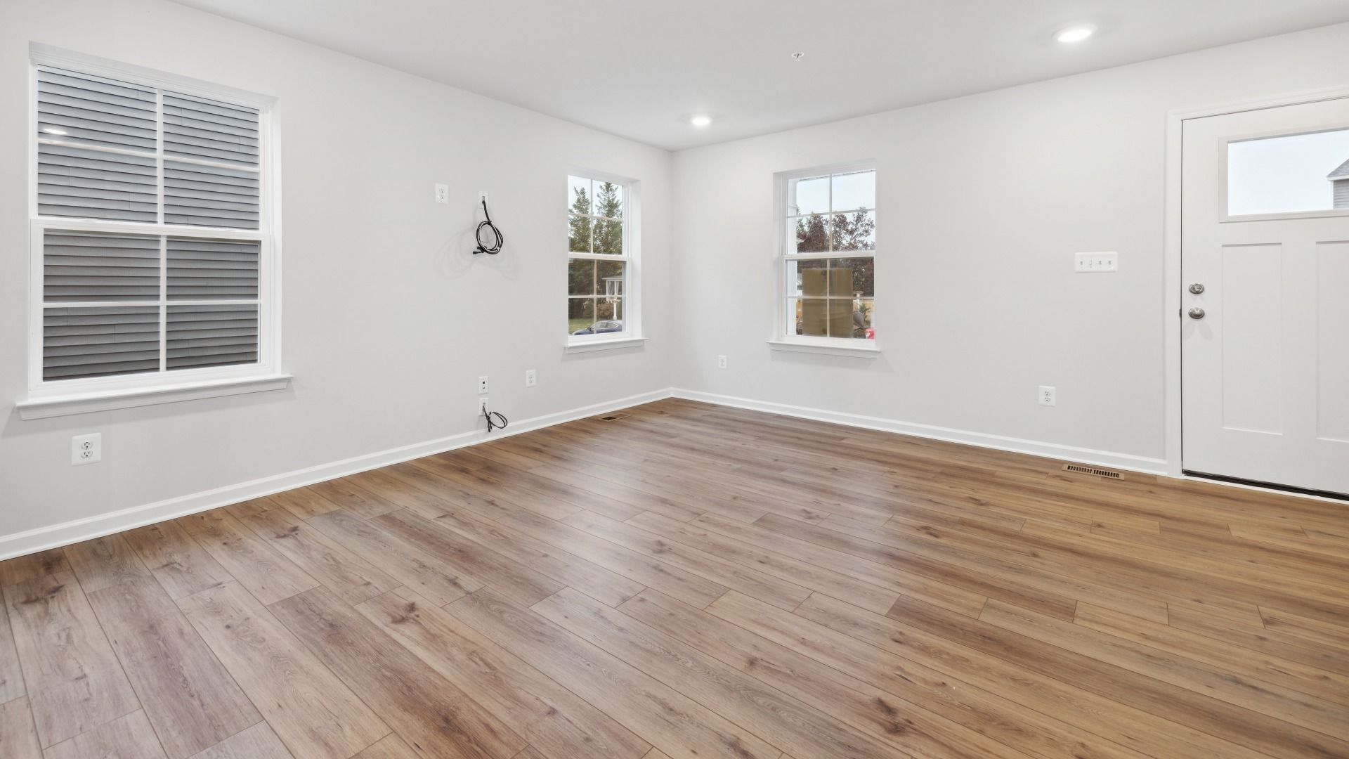 Sunlit Family Room Flows Seamlessly to the Kitchen in the Whitehall at The Village of College Park by DRB Homes.
