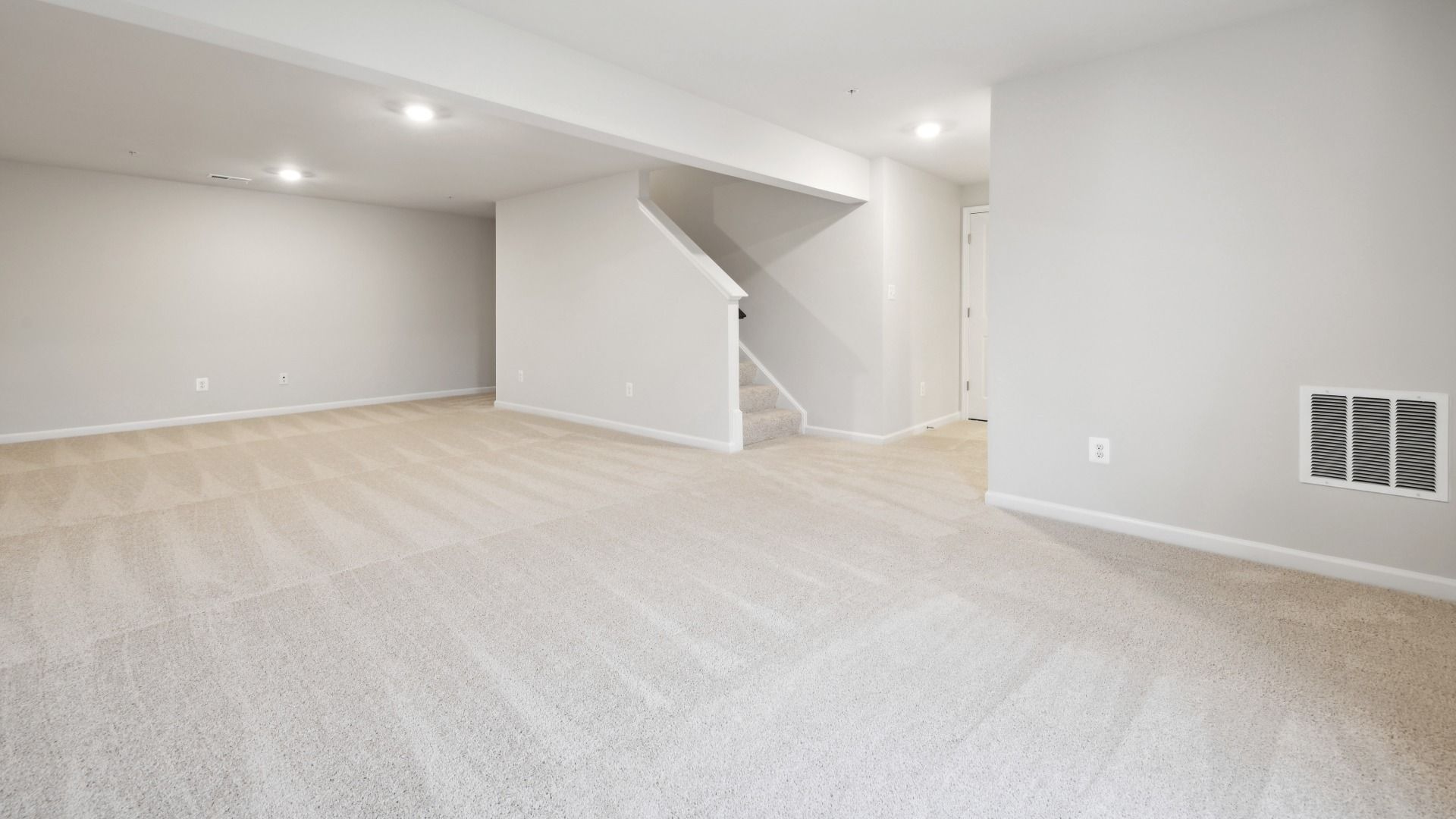Finished Basement with Carpet and a Full Bathroom in the Whitehall at The Village of College Park by DRB Homes.