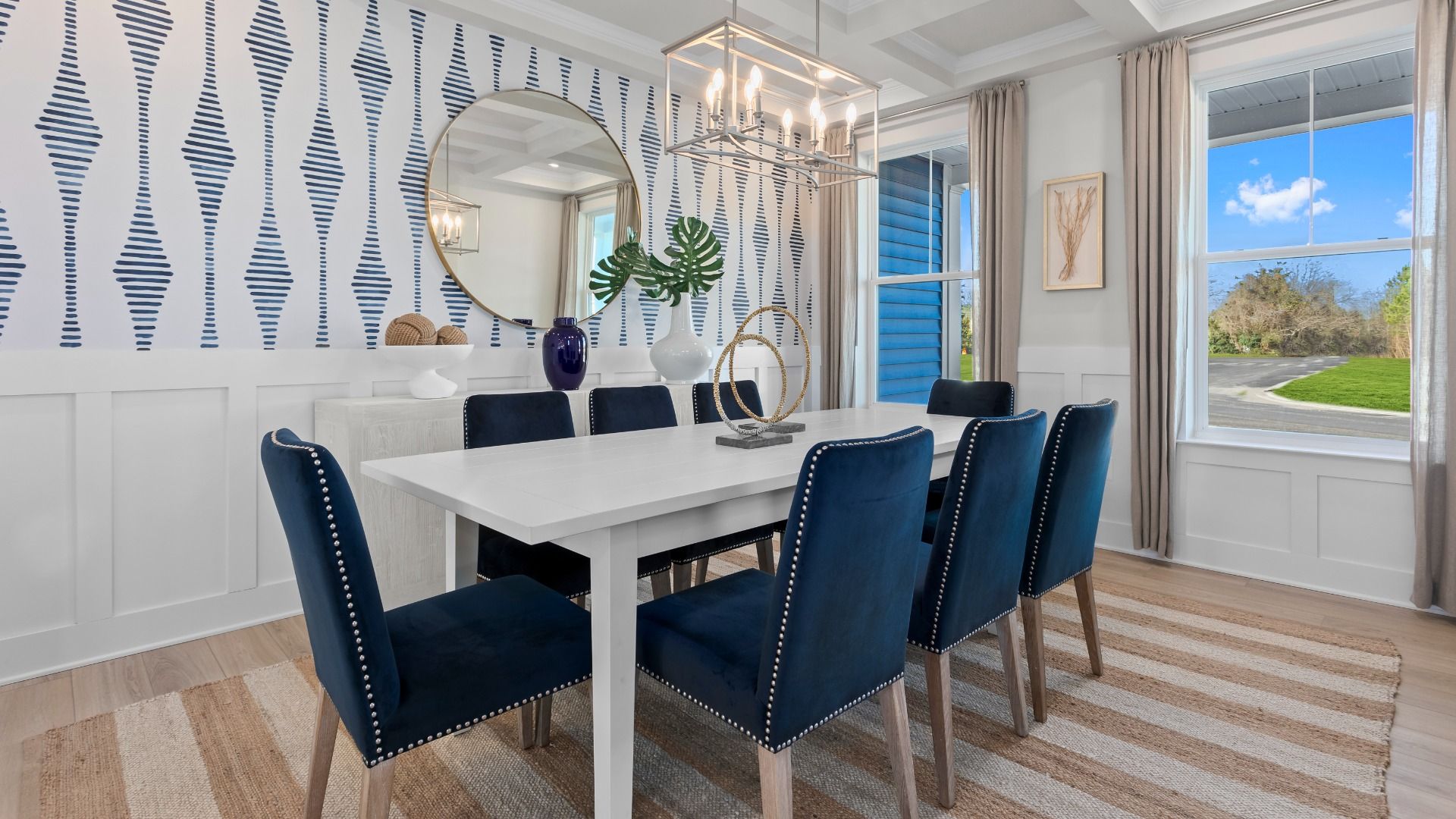 Dining room with coffered ceiling and large windows in the DRB Homes St. Kitts Model at the Wetherby community.