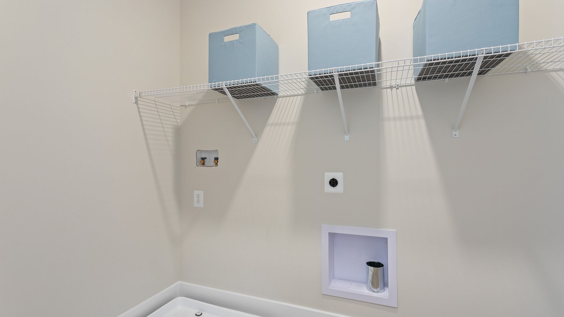 Convenient Laundry Room with Overhead Storage in the Aloha at Wetherby in Millsboro, DE