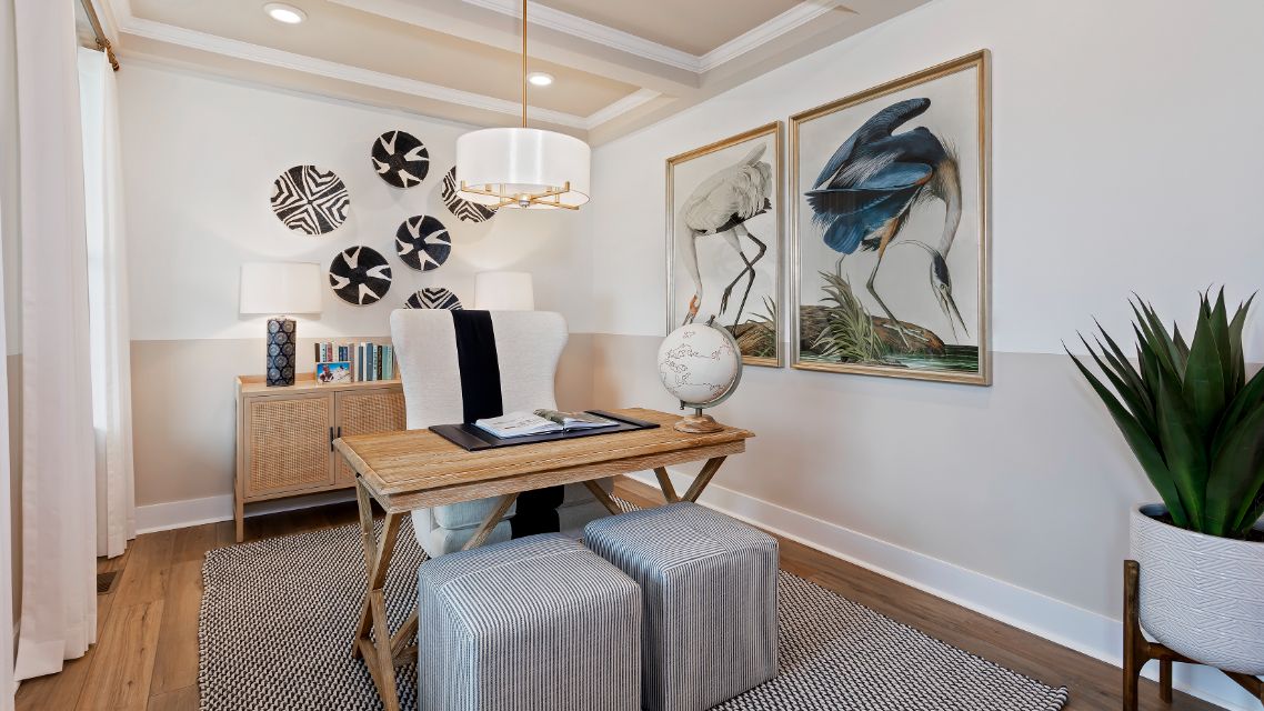 Private study with large window and wood floors in a DRB Homes Barbados model home in The Estuary community.