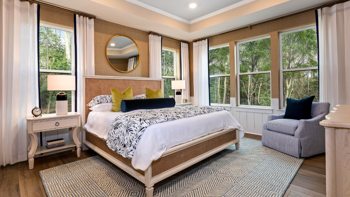 Owner's suite with tray ceiling and 5 windows on adjacent walls in a DRB Homes Barbados model home in The Estuary community.