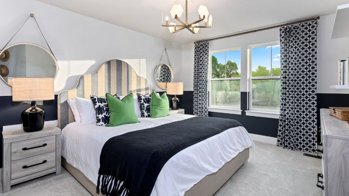 Carpeted secondary bedroom with large double window in a DRB Homes Barbados model home in The Estuary community.