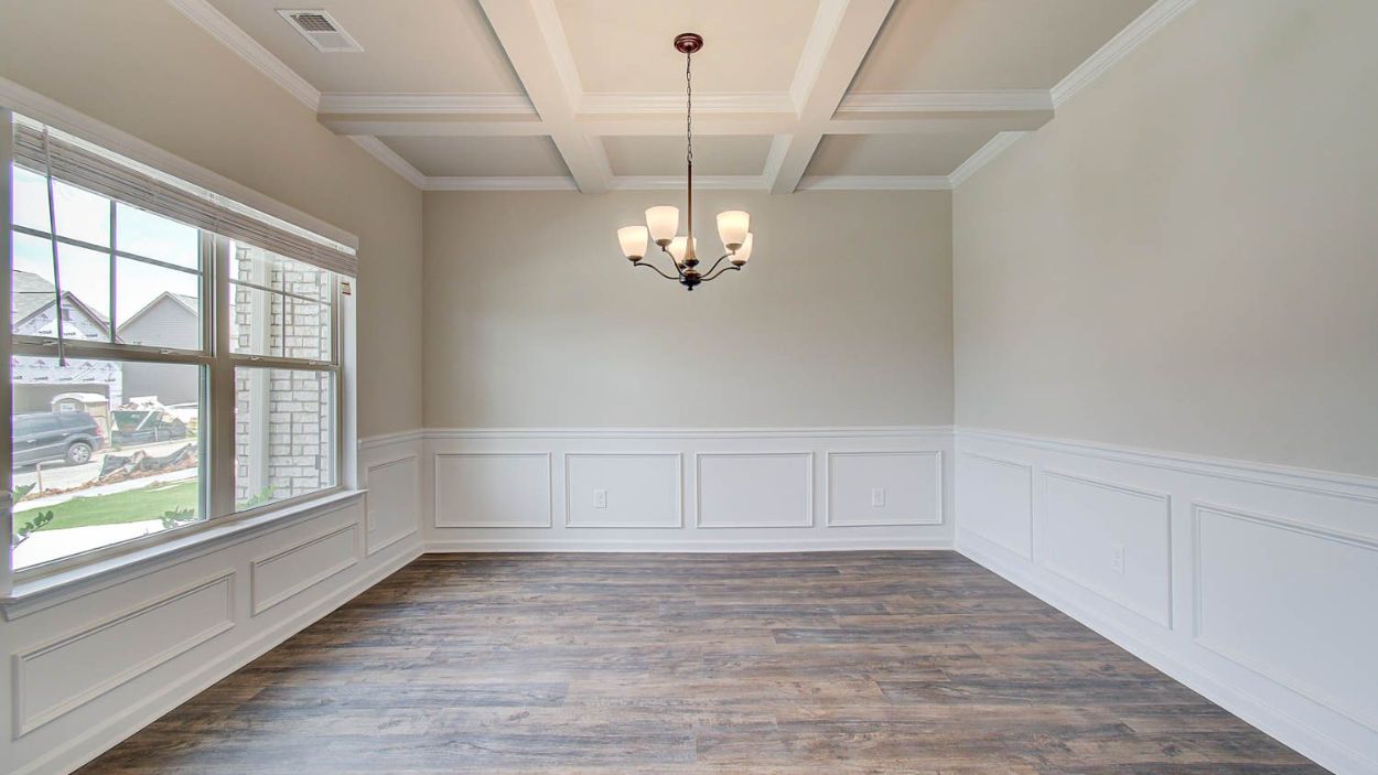 Bright Vickery dining room with chandelier lighting and coffered ceiling at Berkeley Lakes in Locust Grove, GA.