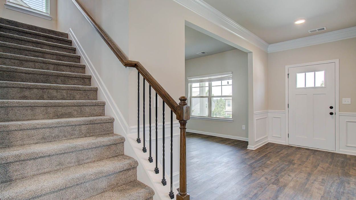 Vickery open foyer featuring access to carpeted stairs with open railing at Berkeley Lakes in Locust Grove, GA.