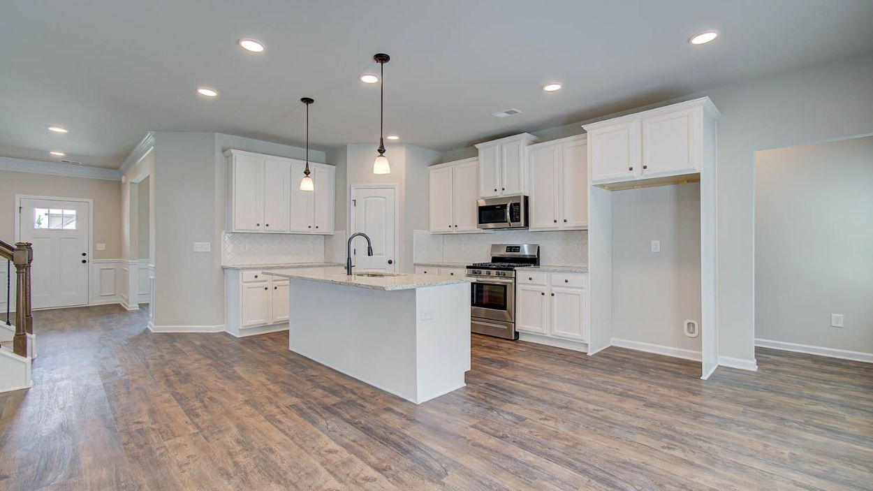 Vickery open-concept kitchen with LVP flooring, ample cabinetry, and large center island at Berkeley Lakes.