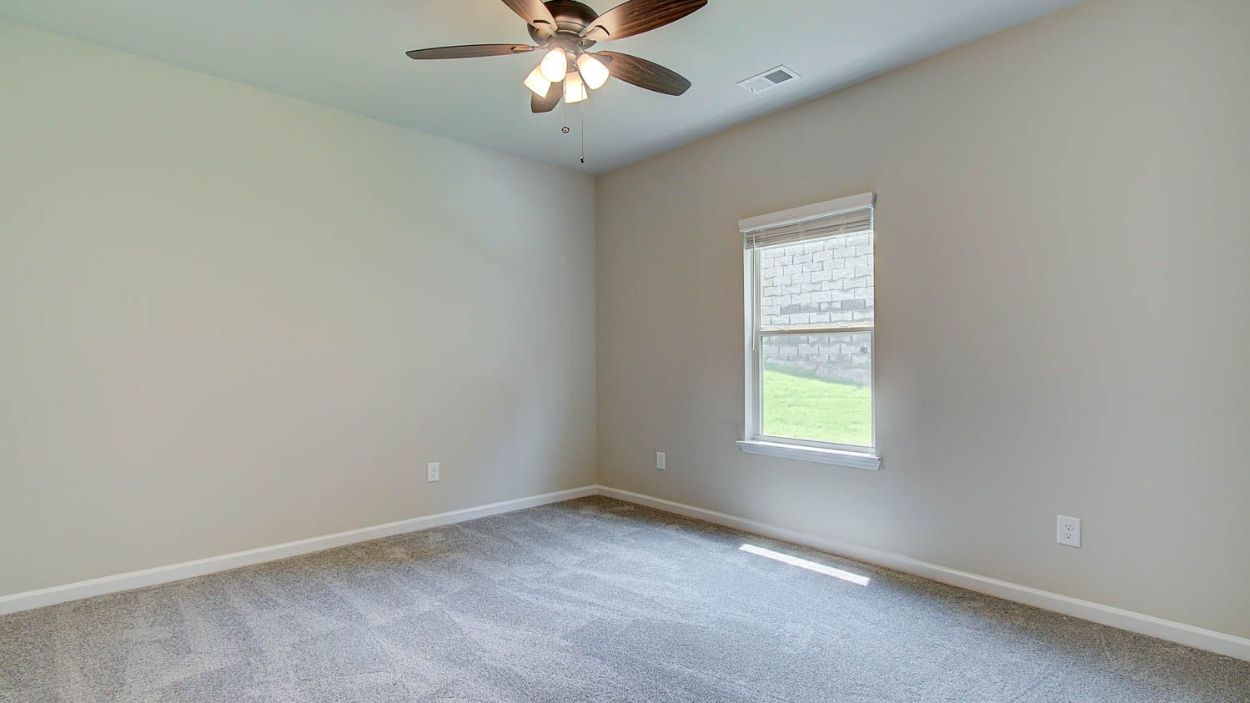 Secondary bedroom with natural light and carpet flooring in the Vickery at Berkeley Lakes in Locust Grove, GA.