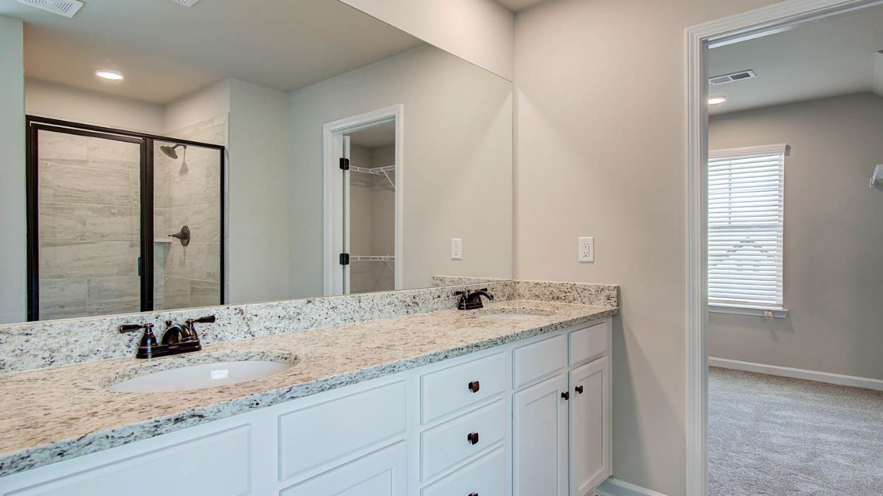 Vickery primary bath with dual vanities, walk-in shower, standalone tub, and neutral modern finishes at Berkeley Lakes.