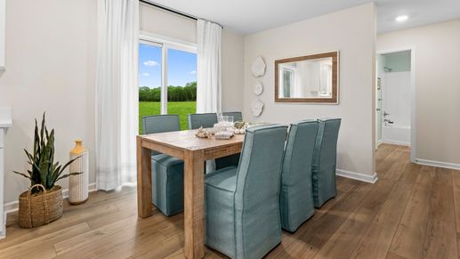 Dining room with large double window in a DRB Homes Whitehall Model at the Village of College Park community.