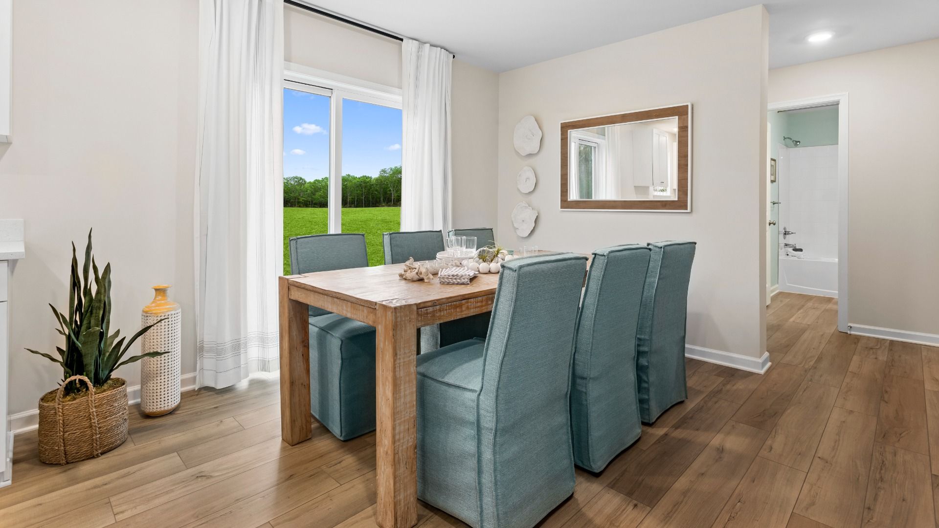 Dining room with large double window in a DRB Homes Whitehall Model at the Village of College Park community.