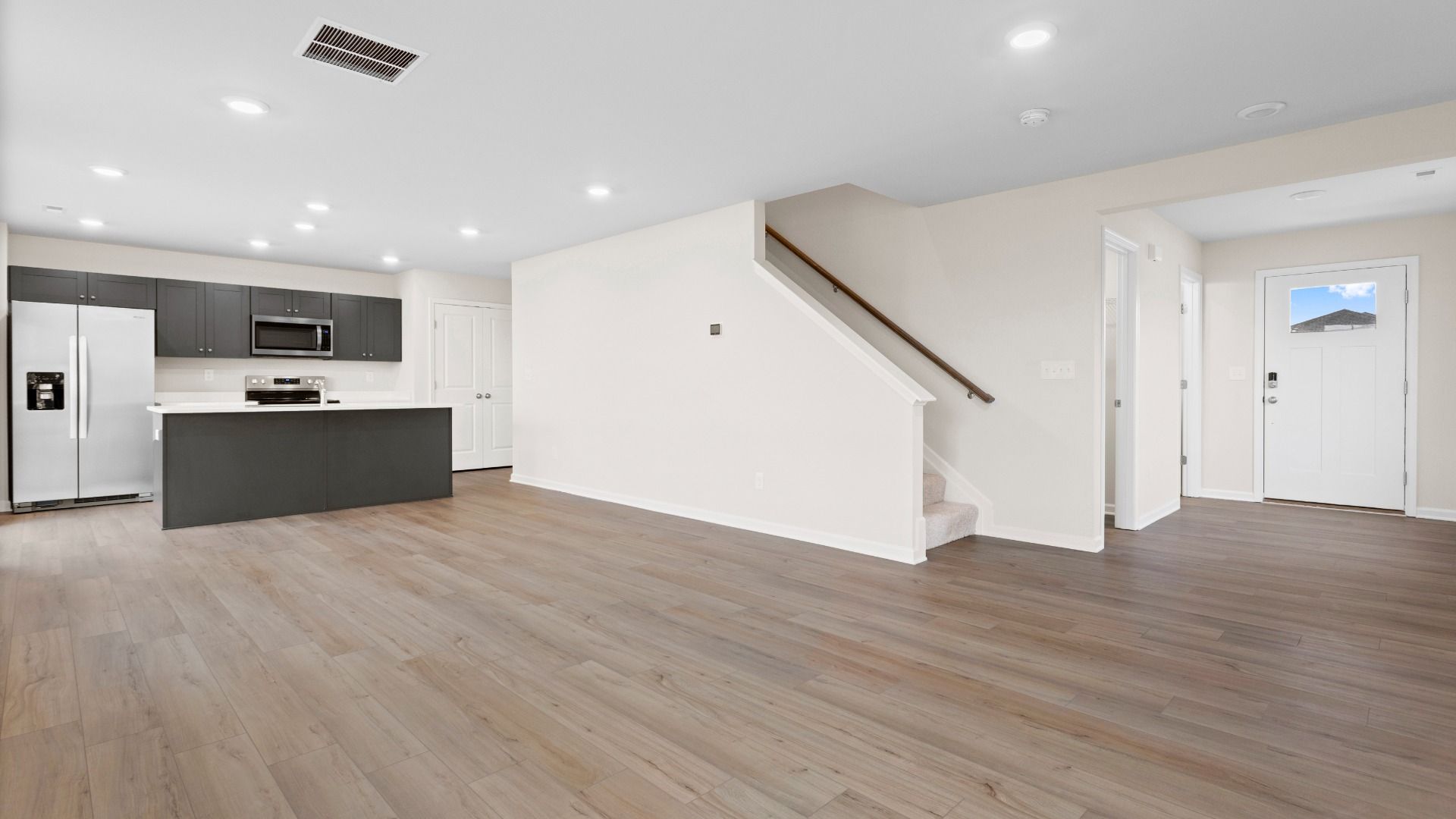 Open 1st floor living room and kitchen in a DRB Homes Glenshaw plan at The Village of College Park.