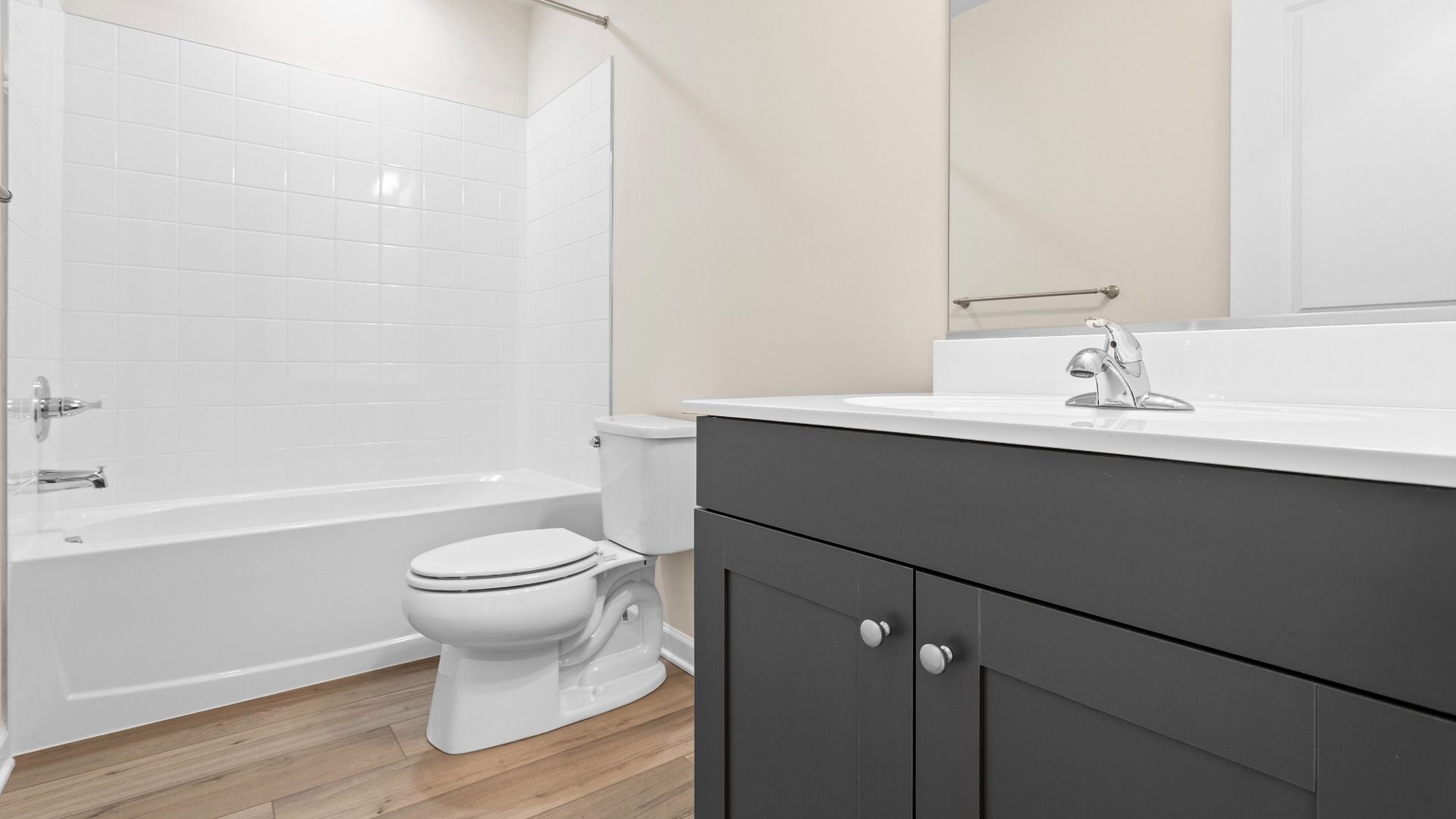 Full bath with dark gray vanity and shower/tub combo in a DRB Homes Glenshaw plan at The Village of College Park.