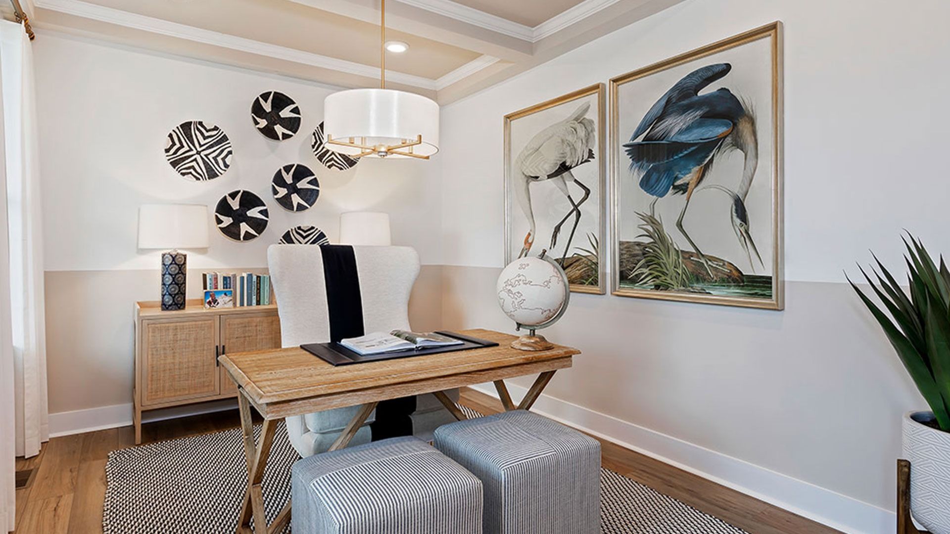 Cozy private study with light wood floors, large window, and recessed lights.