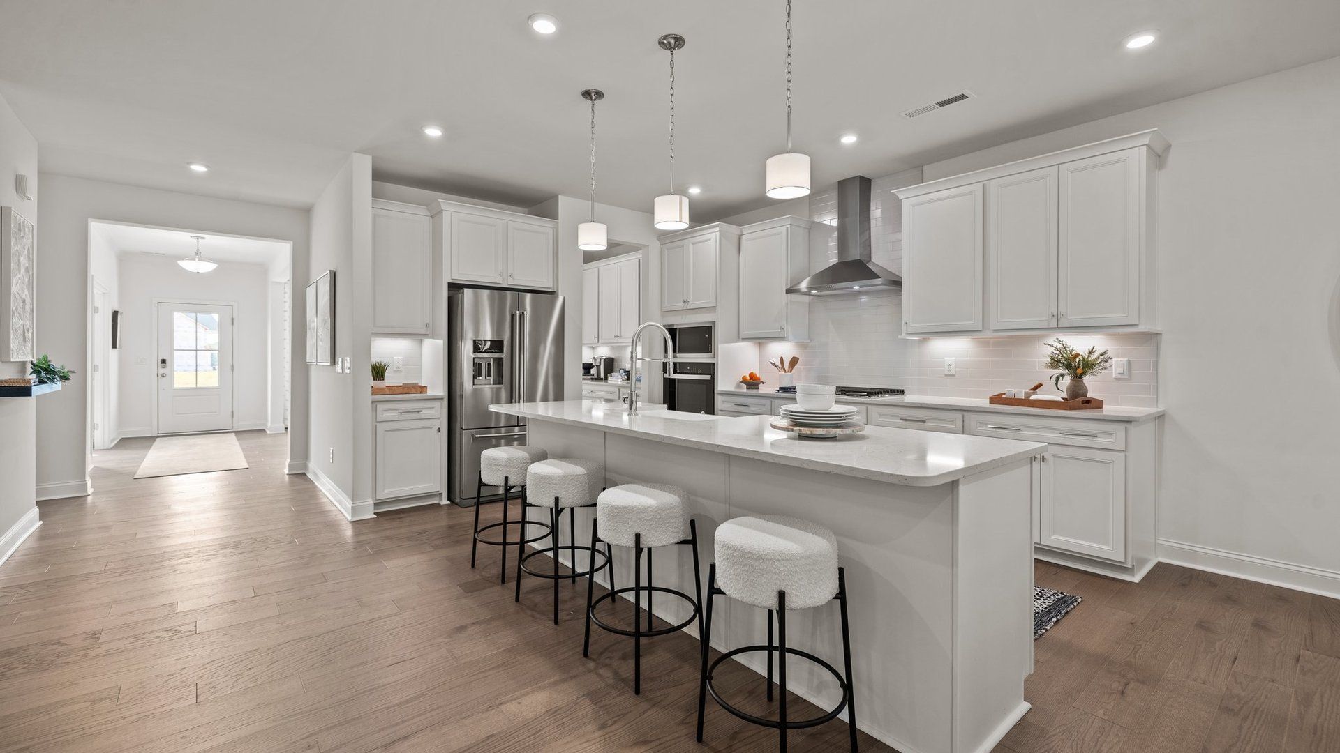 Gourmet kitchen with expansive island, wall oven and microwave, and vented hood, in the Townsend plan at Lakeside Glen