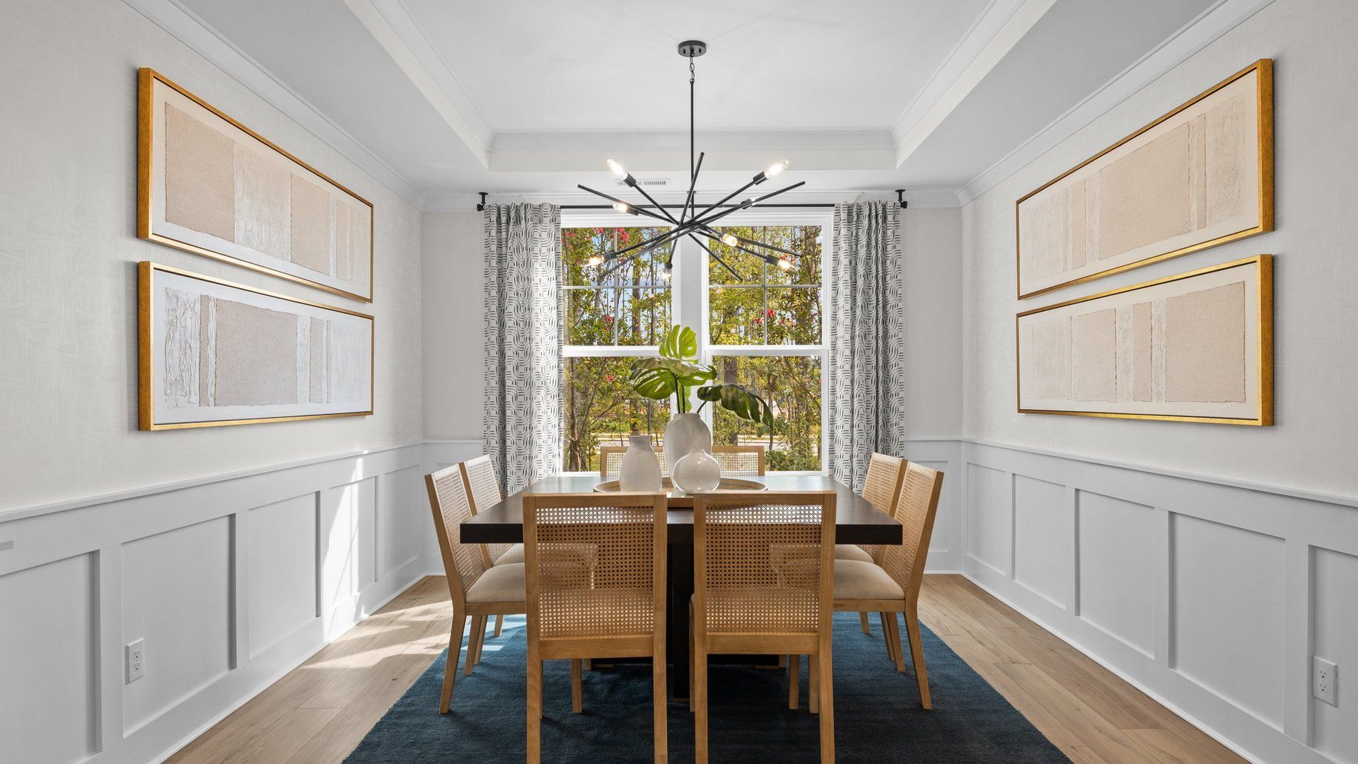 Luxurious formal dining room with tray ceiling and large windows. The Jordan Plan at Lakeside Glen in York, SC, by DRB Homes