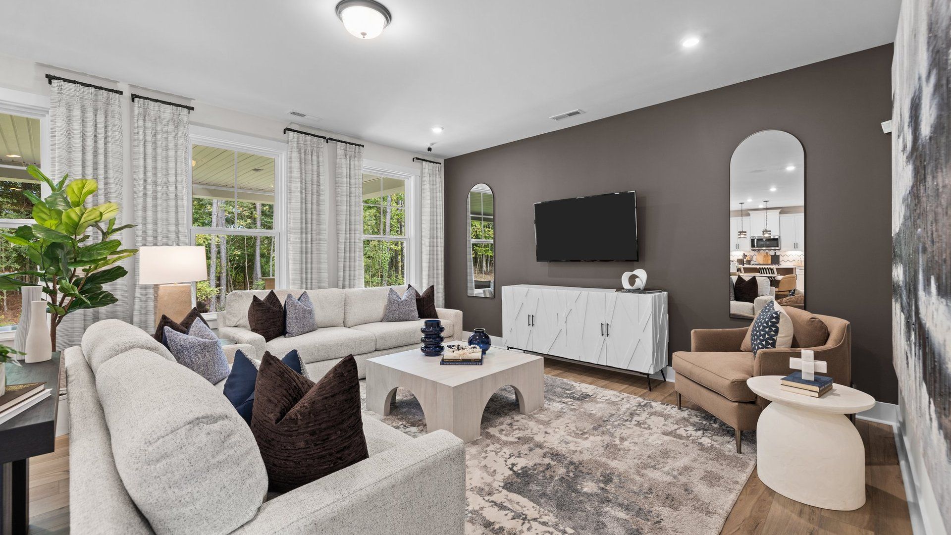 Family room with elevated ceiling and large windows. The Jordan Plan at Lakeside Glen in York, SC, by DRB Homes