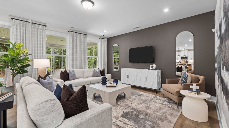Family room with elevated ceiling and large windows. The Jordan Plan at Lakeside Glen in York, SC, by DRB Homes