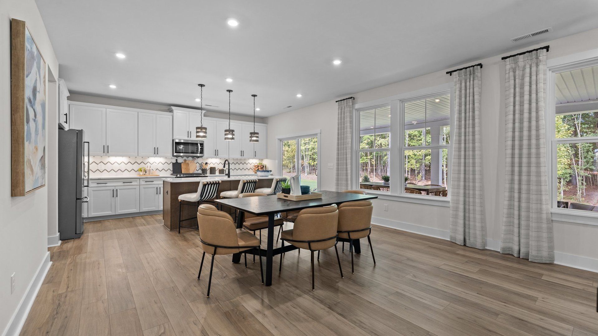 Dining Area with large windows and a spacious kitchen featuring professional design, premium finishes, and ample seating.
