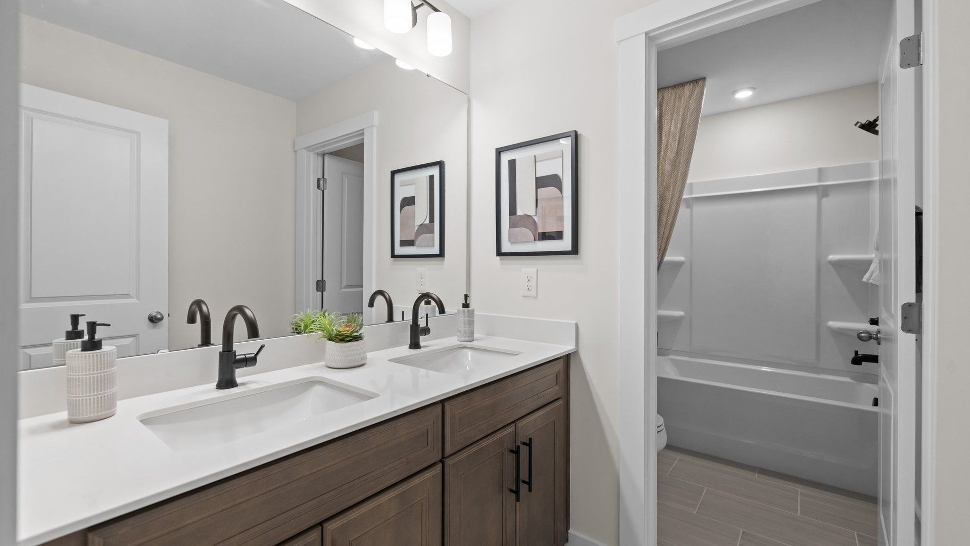 Secondary bathroom with dual vanity, soaking tub, and premium lighting & finishes. Lakeside Glen. DRB Homes. Charlotte, NC