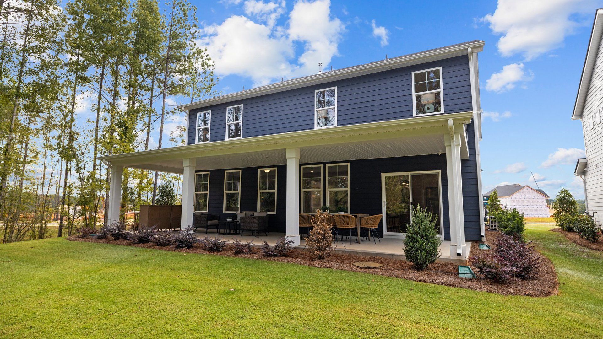 Expansive covered porch with ample seating space, perfect for outdoor relaxation or gatherings. DRB Homes. York, SC.