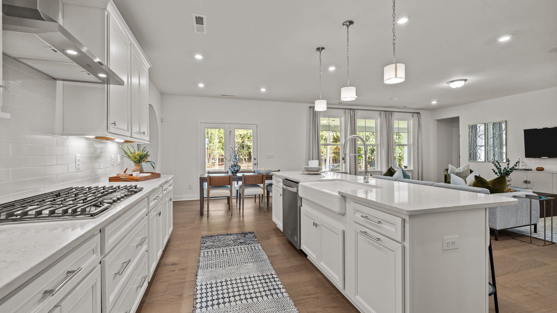 Gourmet kitchen with gas cooktop, vented hood, expansive island with quartz counter tops, in the Townsend Design by DRB Homes