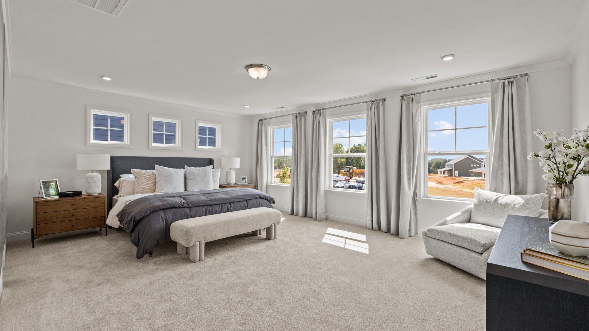 Bright and spacious primary bedroom with elevated ceiling and plentiful windows, in the Townsend Design by DRB Homes York, SC