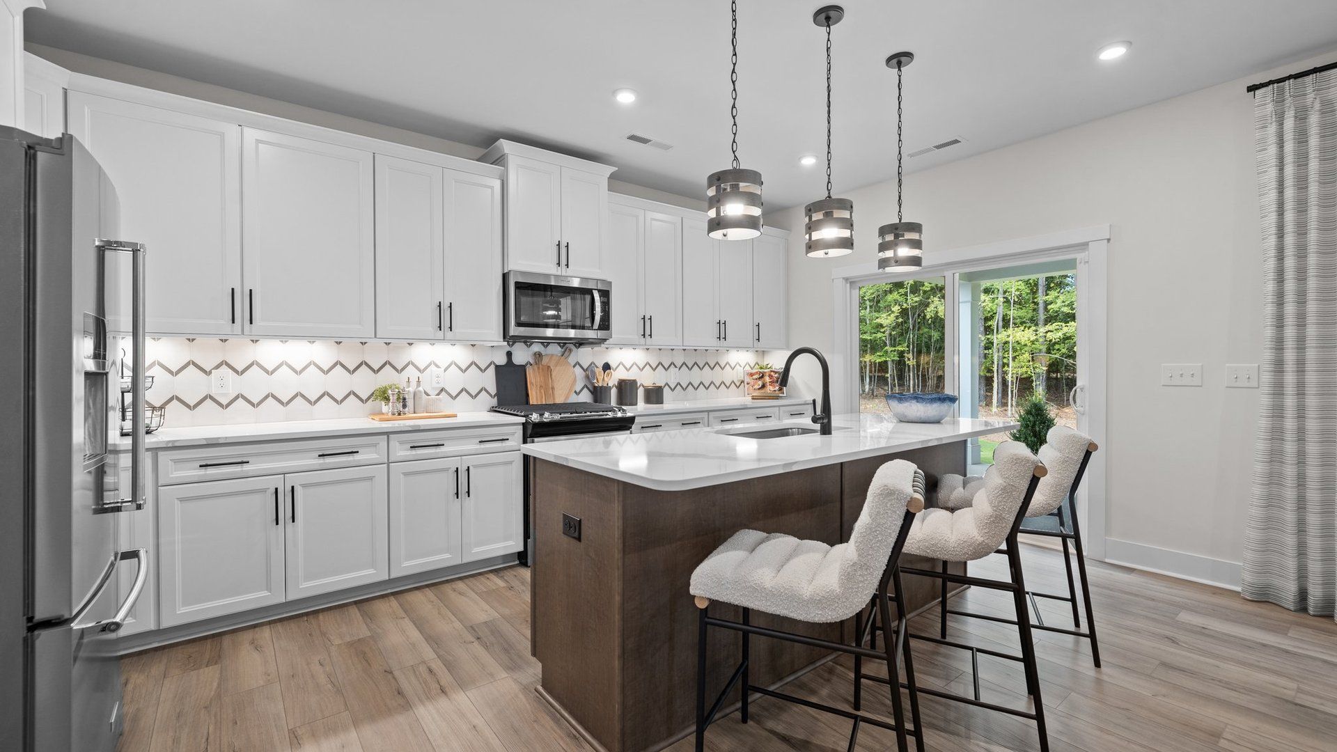 Kitchen with spacious island, premium backsplash, and pendant lighting in the Jordan Design by DRB Homes in York, SC