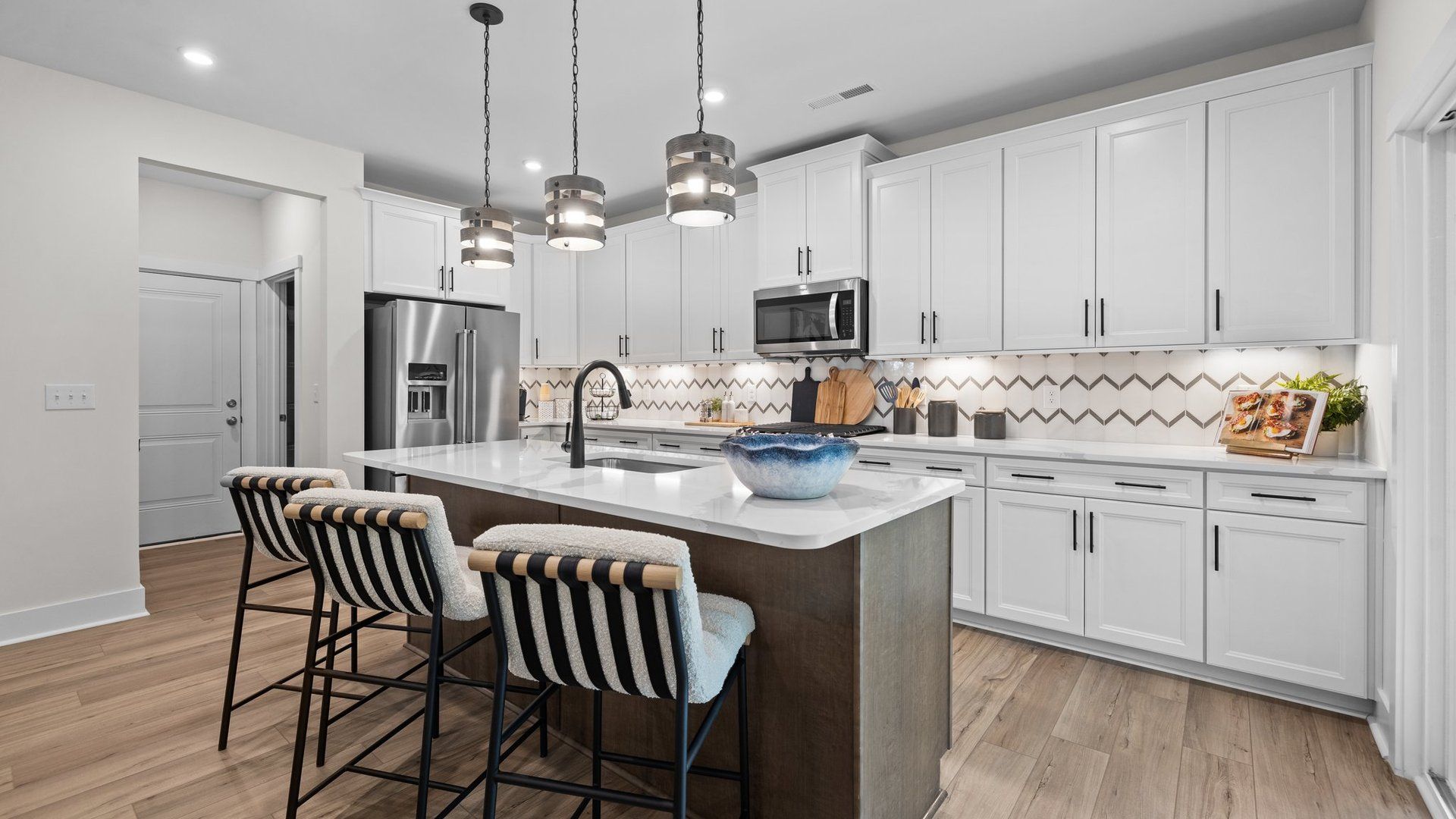 Spacious kitchen with large island, premium backsplash, and pendant lighting, in the Jordan Design by DRB Homes in York, SC