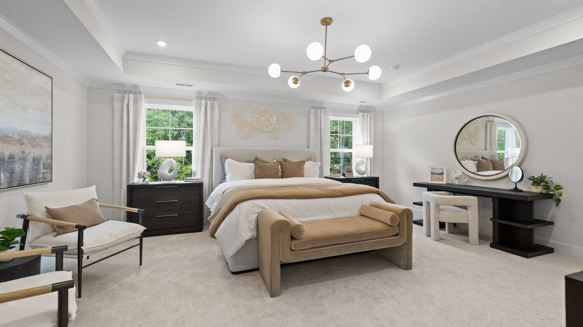 Grand primary bedroom with seating area, elevated tray ceiling, & large windows in the Jordan Design by DRB Homes in York, SC