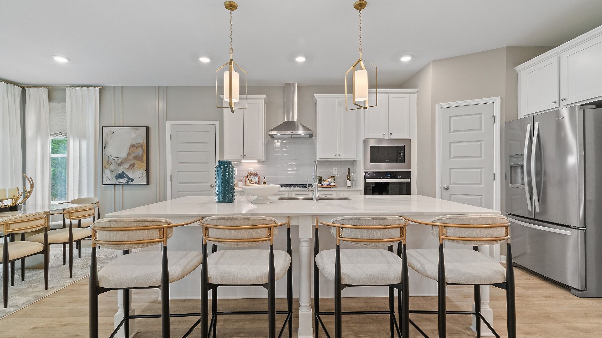 Bright open kitchen with white cabinetry, tile backsplash, and large island at Trinity Park in McDonough, GA.