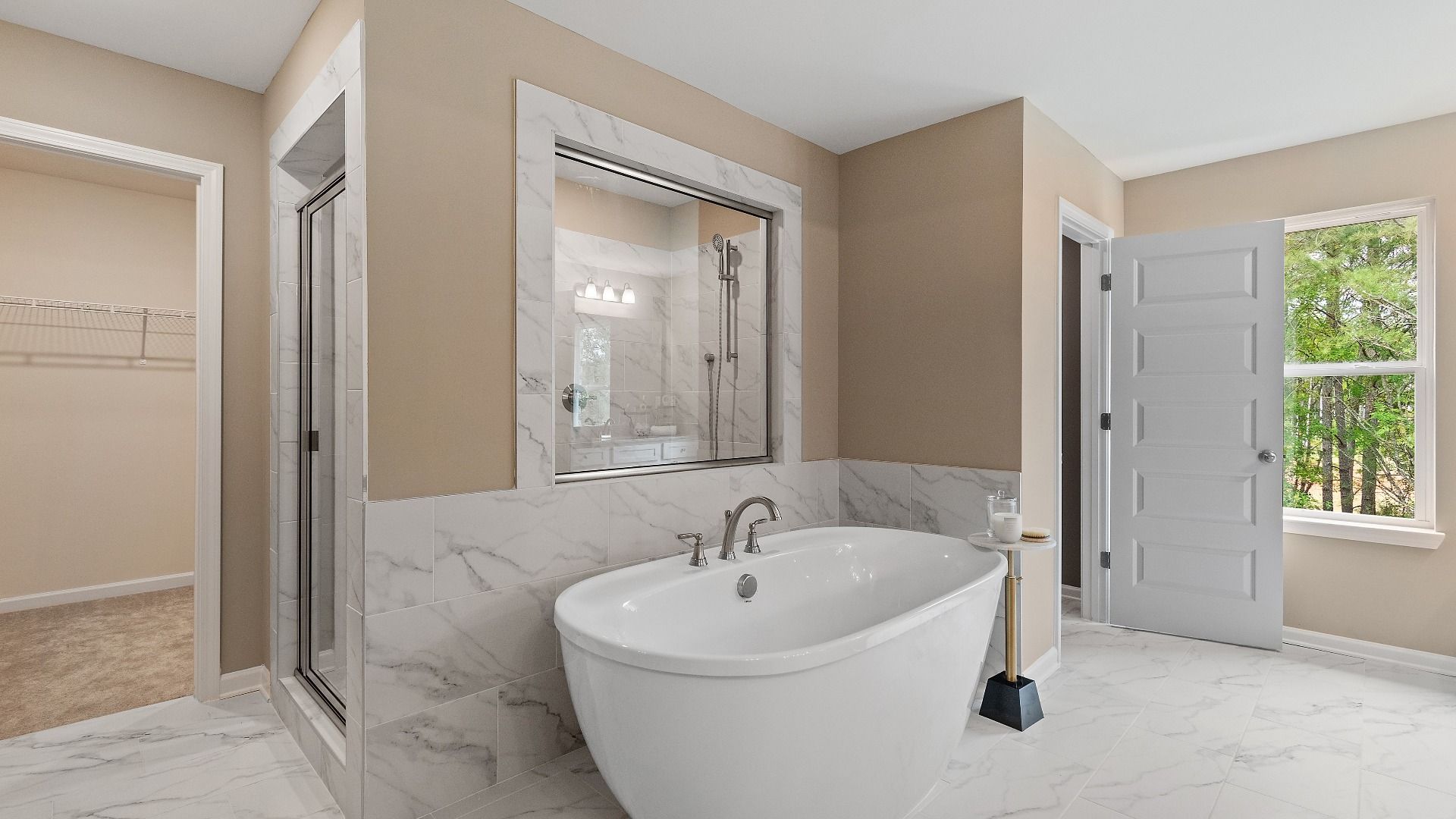 Luxury primary bath with tile flooring and accents, freestanding tub, and walk-in shower at Trinity Park in McDonough, GA.