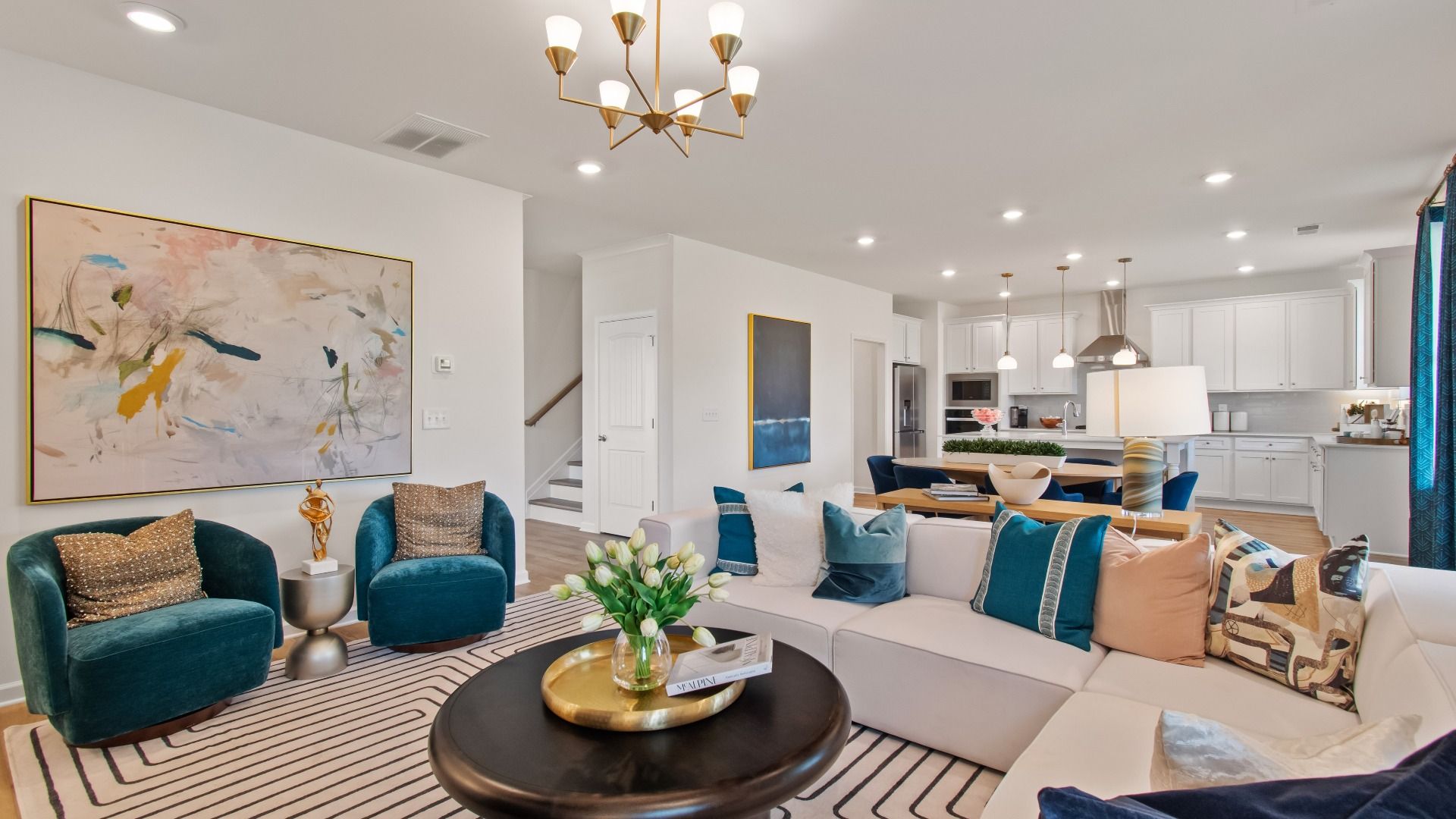 Open-concept family room with LVP flooring, chandelier lighting, and ample seating area at Burchwood in Stockbridge, GA.