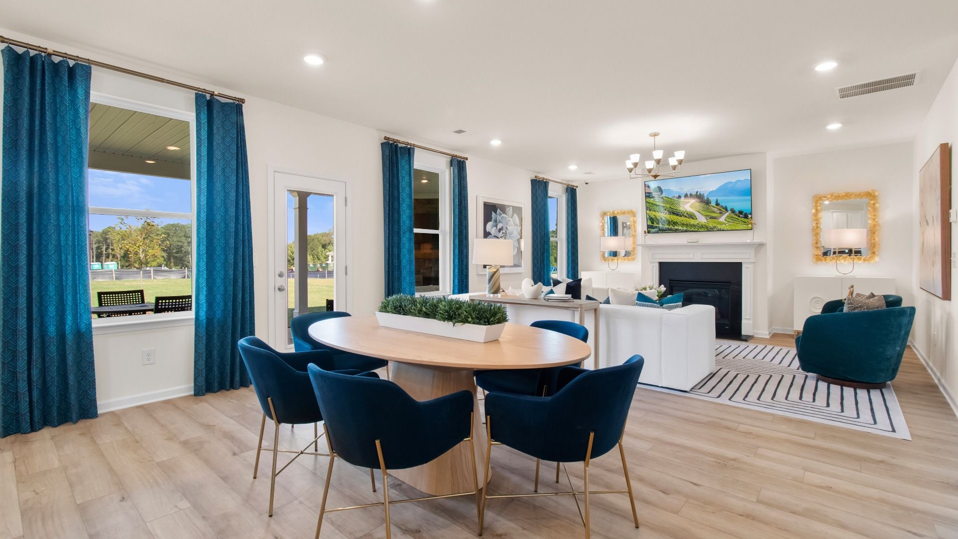Open breakfast area with LVP flooring and views of family room and porch in the Wagener at Burchwood in Stockbridge, GA.