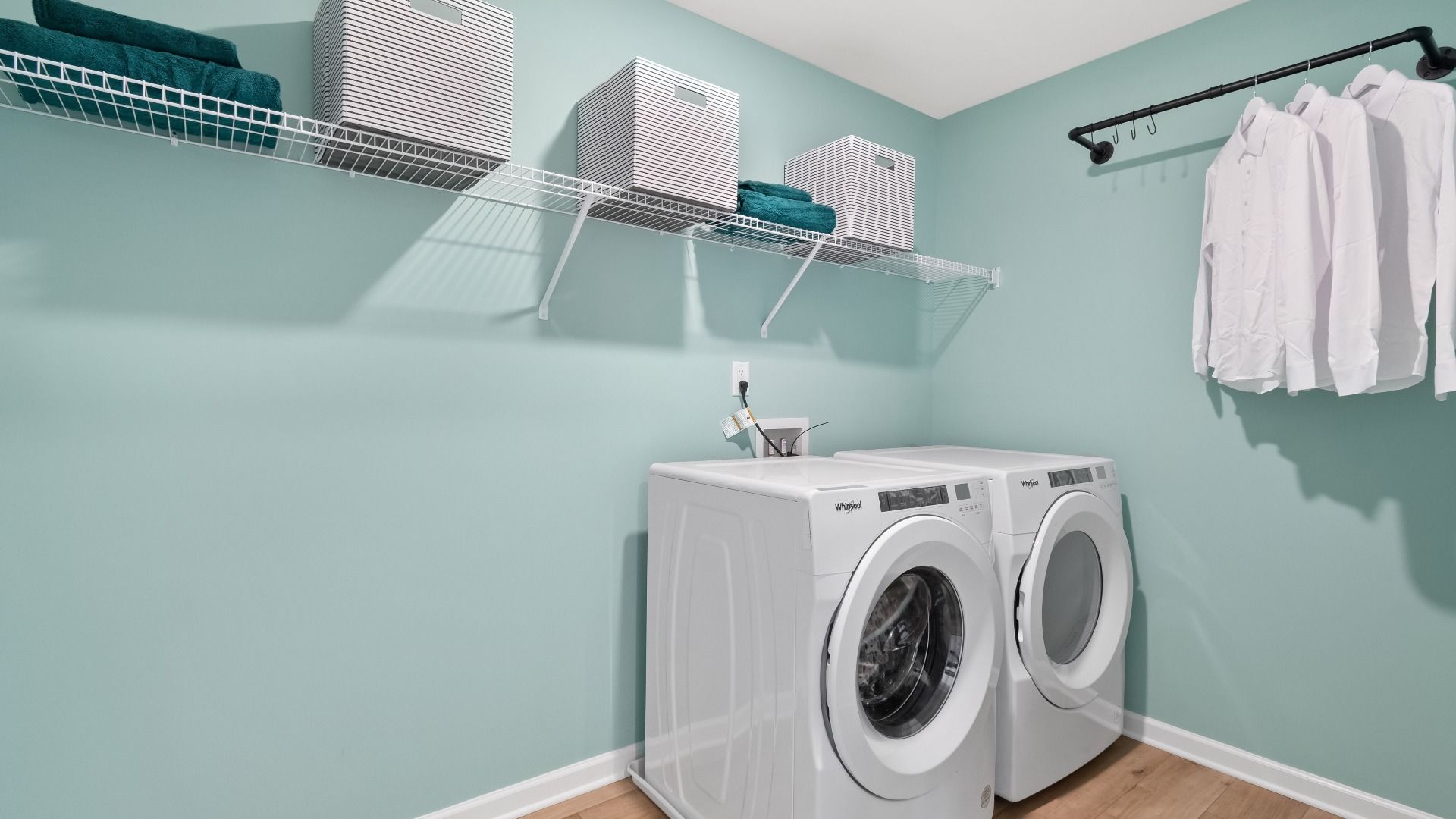 Second floor laundry room with LVP flooring and built-in shelving in the Wagener at Burchwood in Stockbridge, GA.